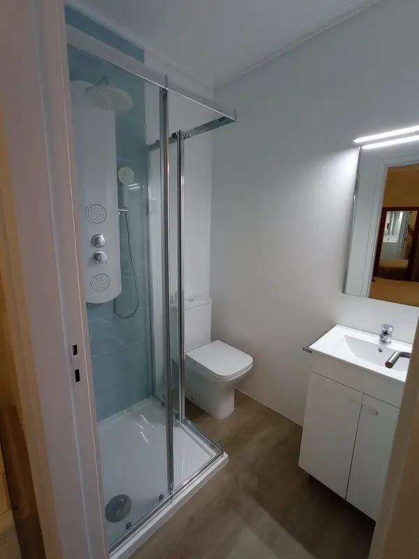 Base de duche com resguardo de vidro, sanita e móvel de lavatório