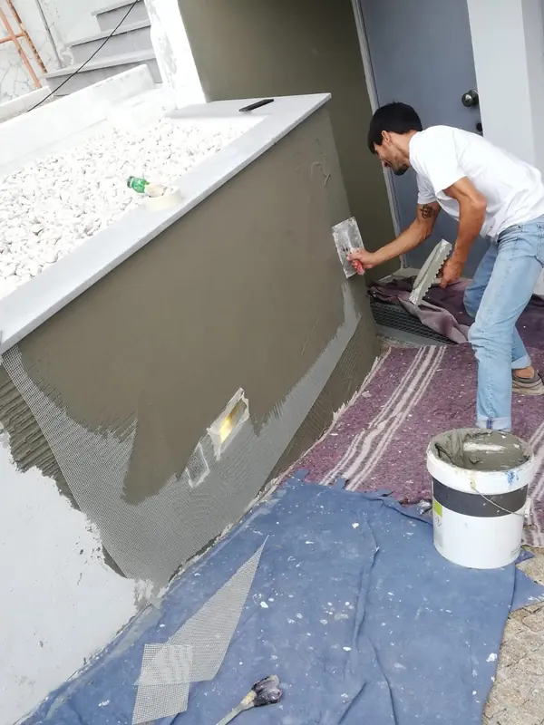 Aplicação de argamassa numa floreira exterior durante a obra