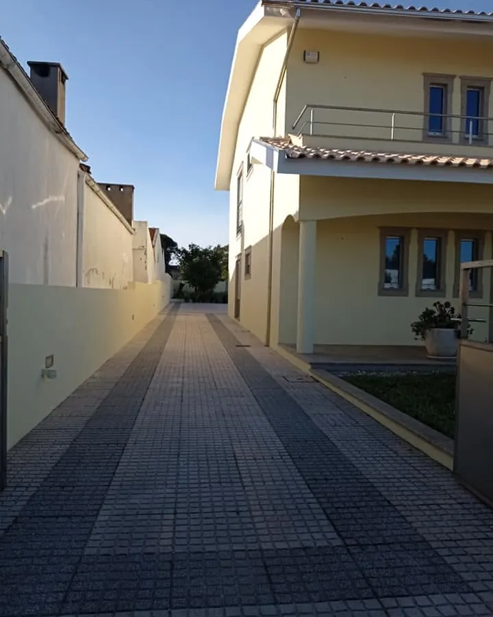 Moradia com a fachada pintada de amarelo e a entrada limpa, depois da obra