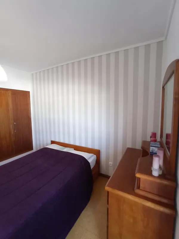 Quarto com parede às riscas e mobília em madeira